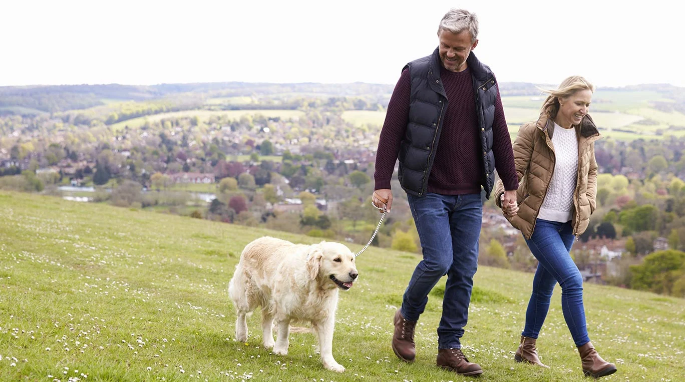 a man and woman walking a dog
