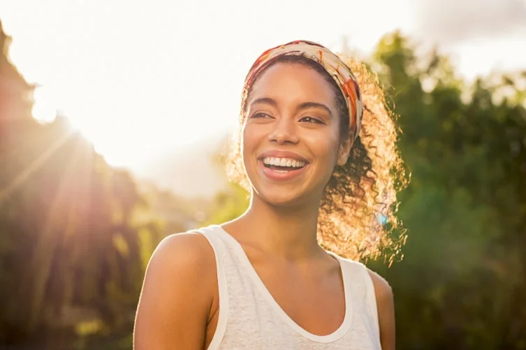 A smiling woman outdoors on a sunny day